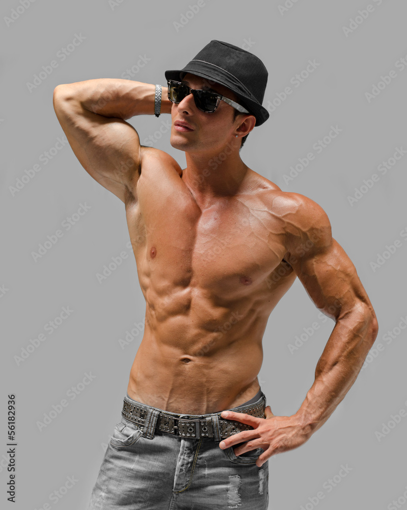 Handsome young man naked, wearing only jeans and hat