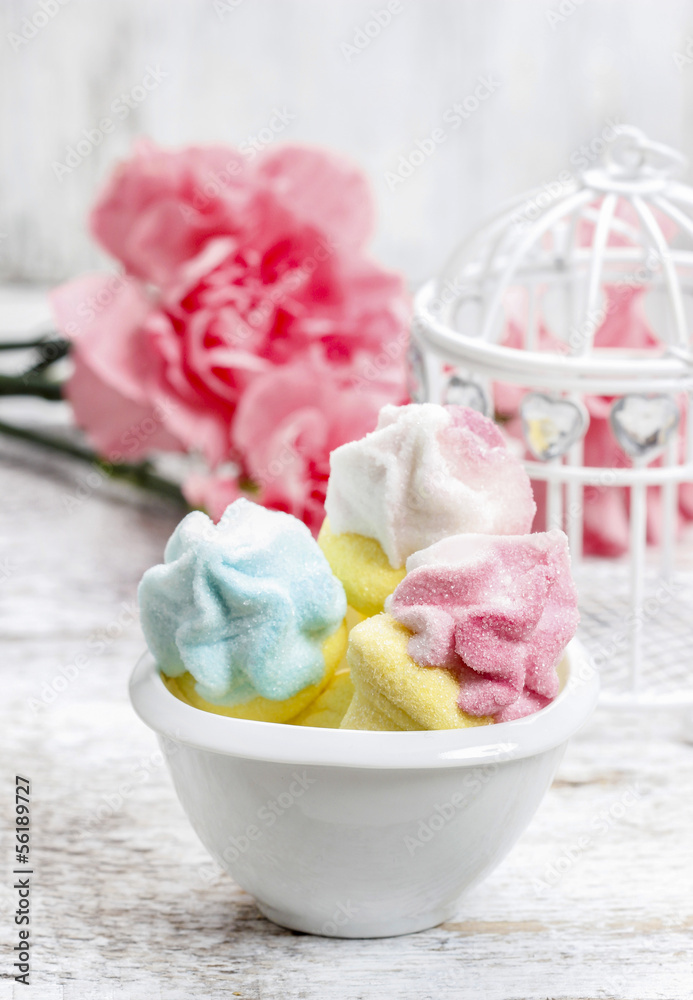 Marshmallows in white bowl among pink carnations Marshmallows in white bowl among pink carnations