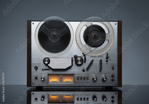 Vintage working analog recorder reel to reel on dark background