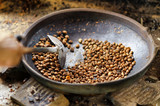 Coffee beans are roasting in pan. Traditional techniques
