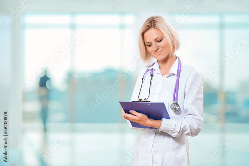 female doctor writng in clipboard photo