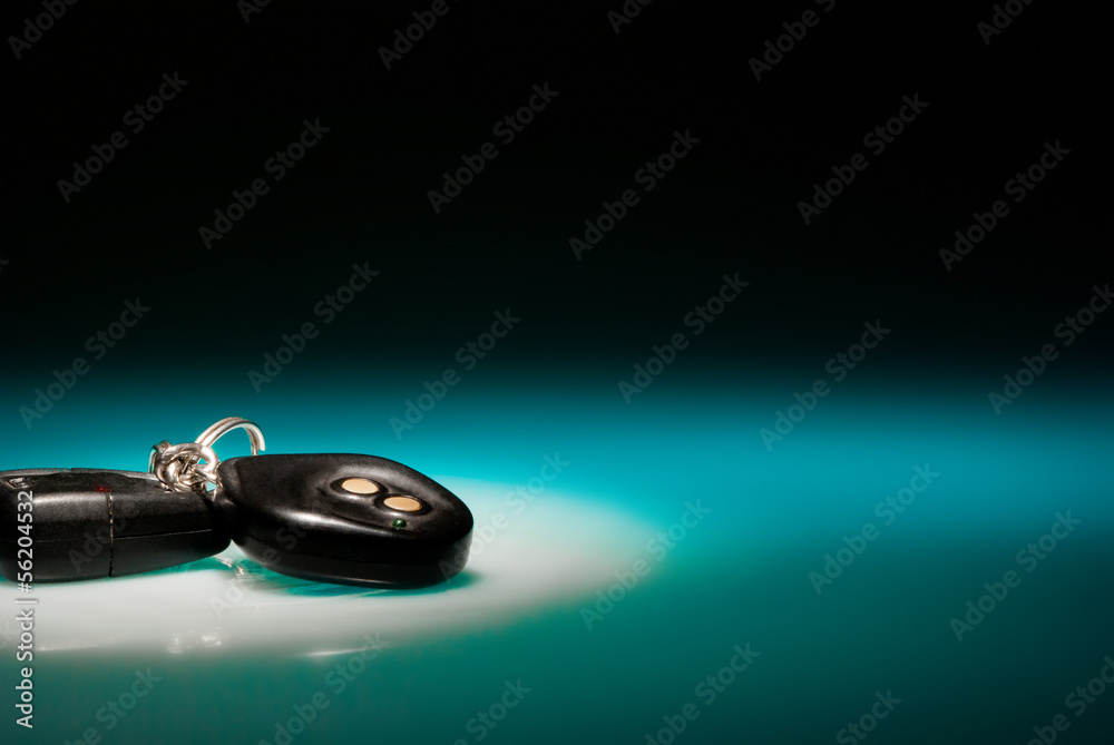 Car keys on blue, reflective table and black background - obrazy, fototapety, plakaty 
