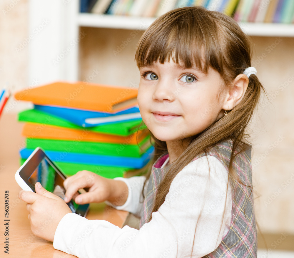 little girl using tablet computer. looking at camera