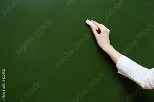 hand holding a white chalk about to write