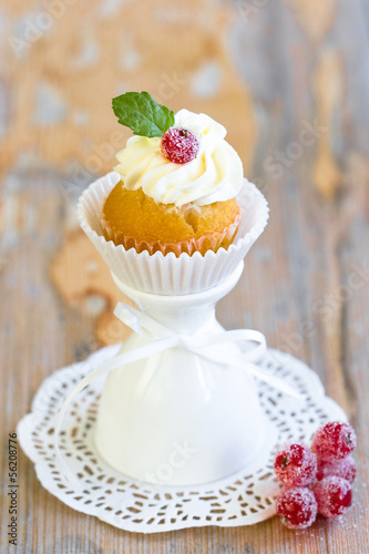 Cupcake with sugared berry and fresh mint leaf photo