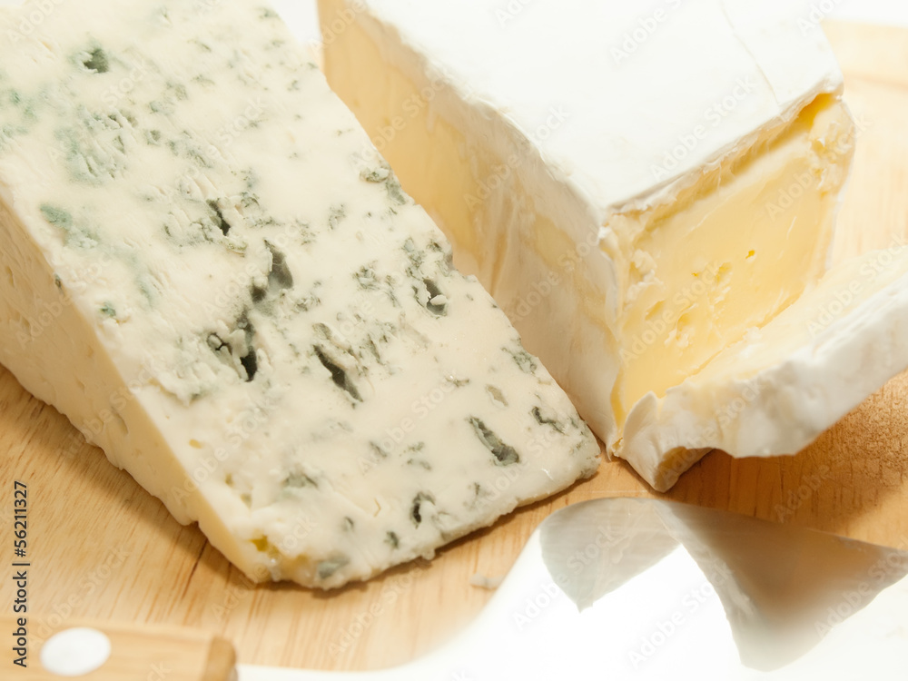 Brie and dor blue cheese on wooden desk with knife