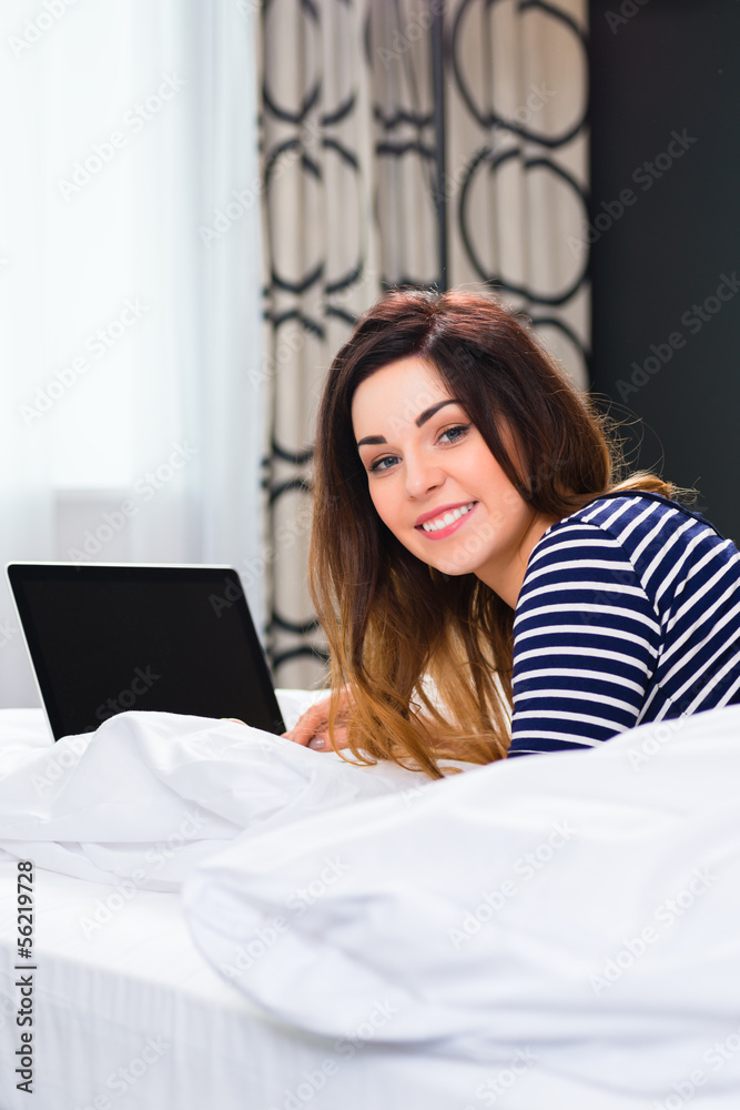 Young woman in Hotel in bed with wifi and computer Young woman in Hotel in bed with wifi and computer