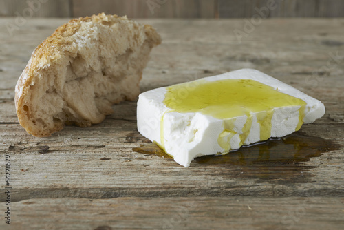 Fresh feta cheese full of olive oil and a piece of bread