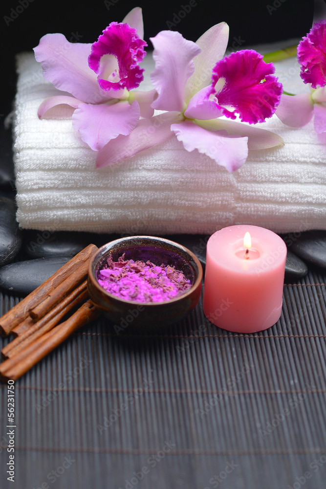orchid on towel and stones ,candle, salt in bowl on mat orchid on towel and stones ,candle, salt in bowl on mat