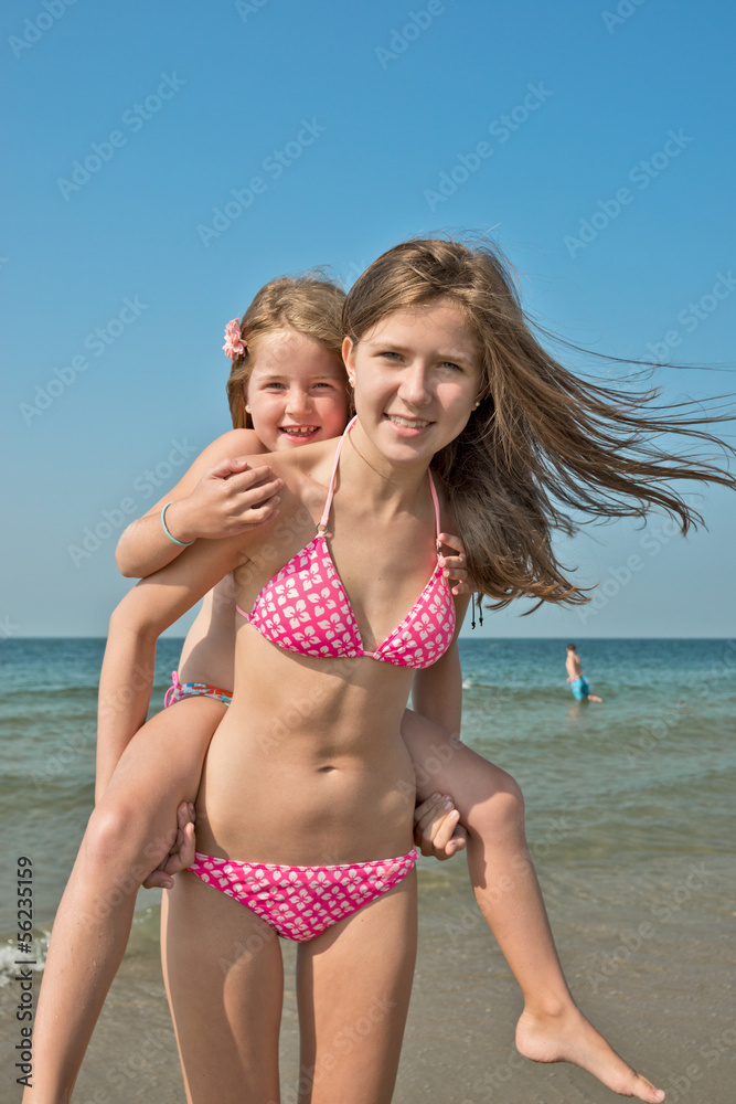 Mädchen am Strand, huckepack