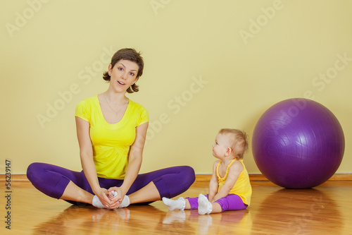 Mother do phisical exercises with her daughter at home photo