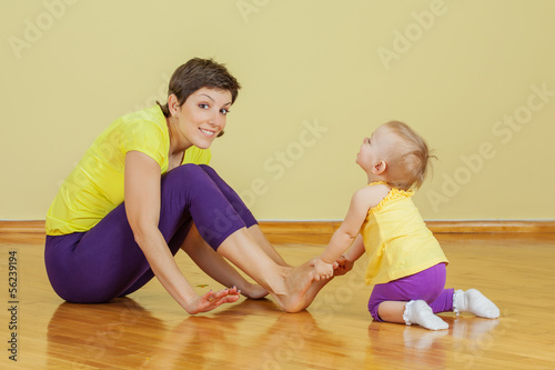 Mother do phisical exercises with her daughter at home