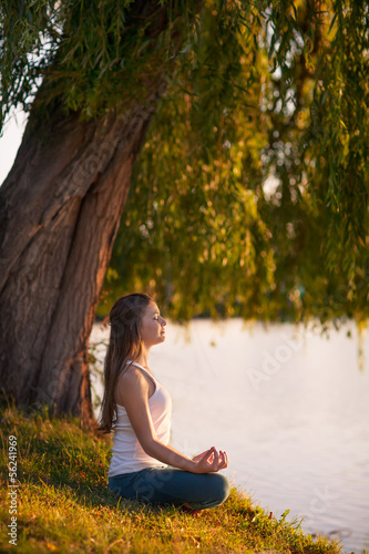 Caucasian woman practicing yoga at lake © Maygutyak