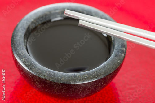 Soy Sauce - Chopsticks resting on a bowl of asian dipping sauce.