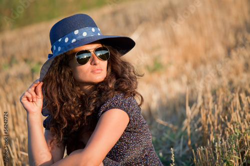 Portrait of a young woman with hat and sunglasses. © dechevm