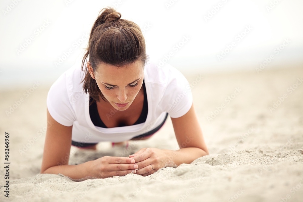 Fitness Woman on the Beach Doing Core Exercises