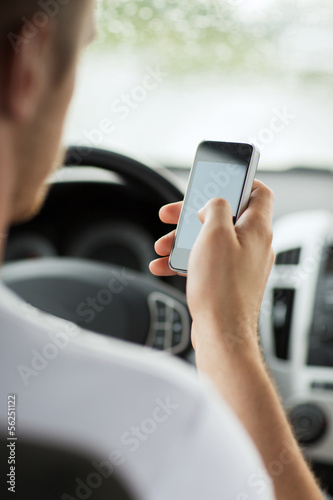 man using phone while driving the car