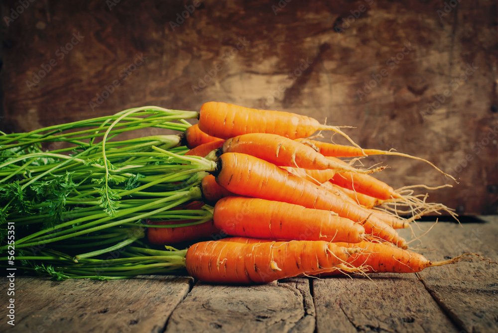 Fresh Organic Carrots lies on wooden background, horizontal, ton - obrazy, fototapety, plakaty 