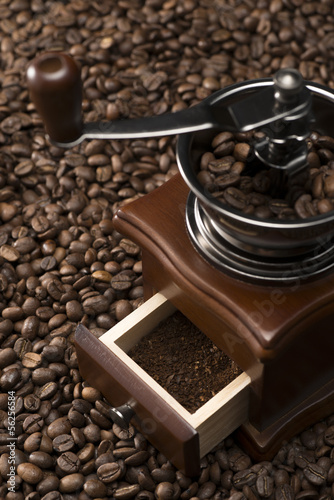 コーヒー豆の背景の上にコーヒーミル
