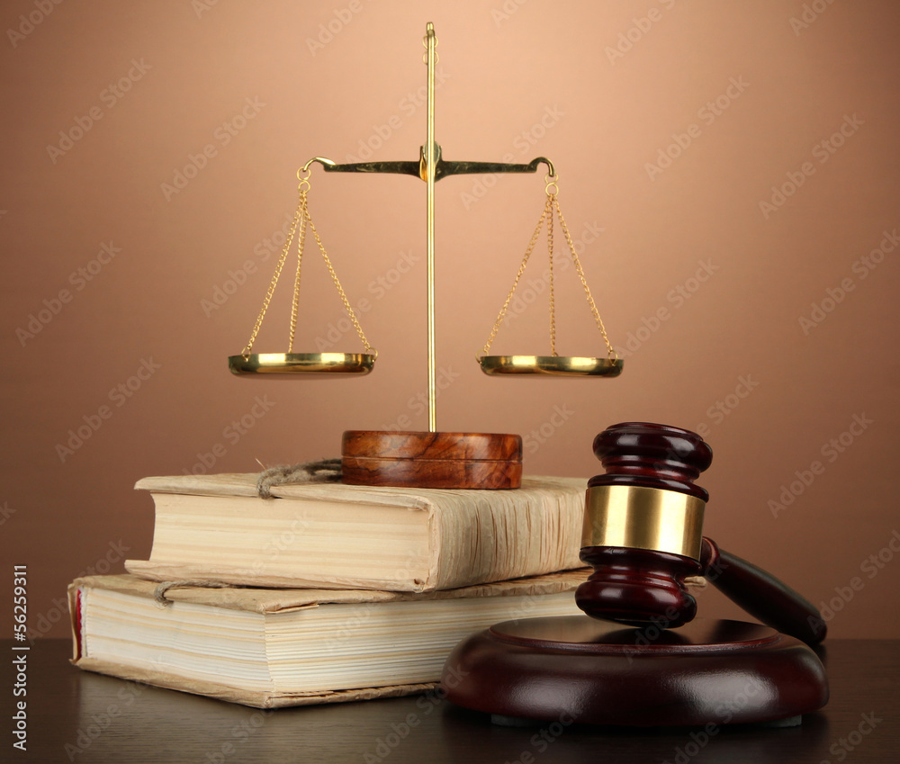 Golden scales of justice, gavel and books on brown background Golden scales of justice, gavel and books on brown background