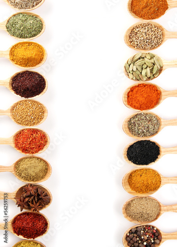 Assortment of spices in wooden spoons, isolated on white