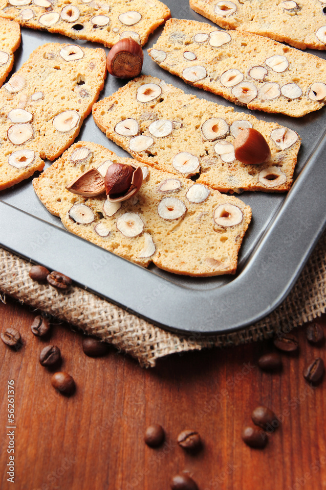 Biscotti with hazelnuts, on dripping pan, on wooden background Biscotti with hazelnuts, on dripping pan, on wooden background
