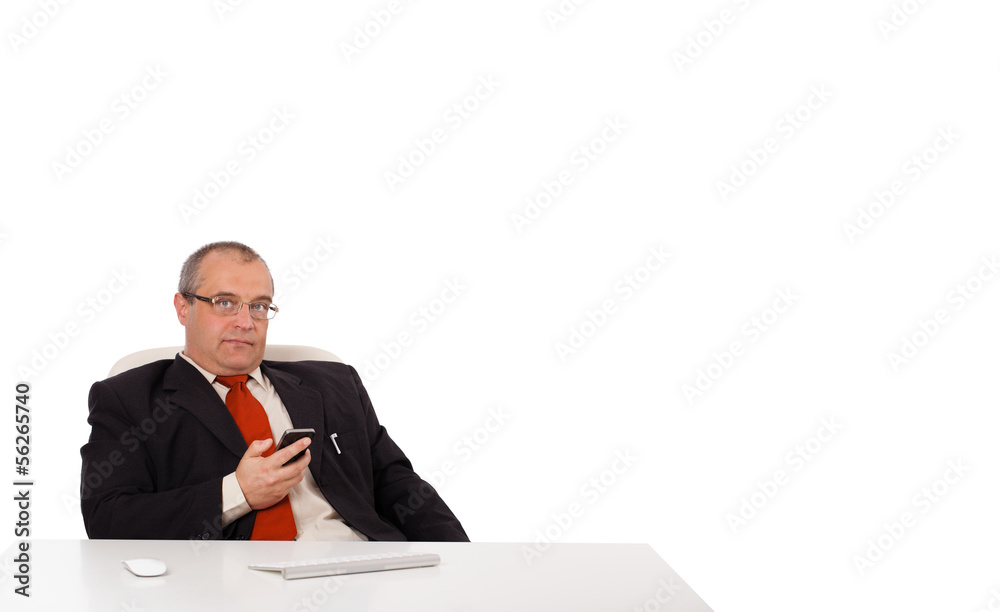 businessman sitting at desk and holding a mobilephone with copys businessman sitting at desk and holding a mobilephone with copys