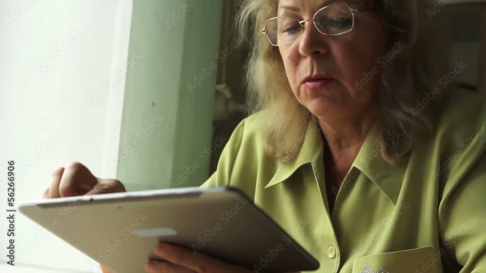 Portrait of a woman at the age with Tablet PC