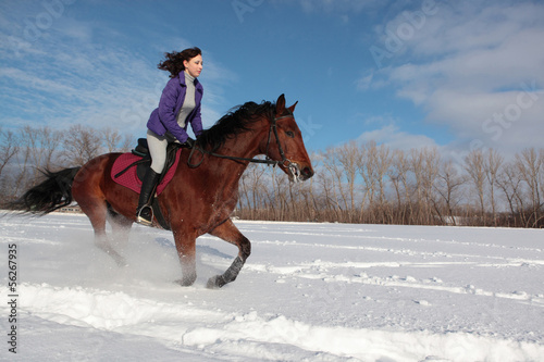 Young woman riding horseback in winter park