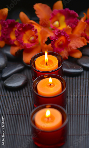 Three candle with orchid and stones at spa