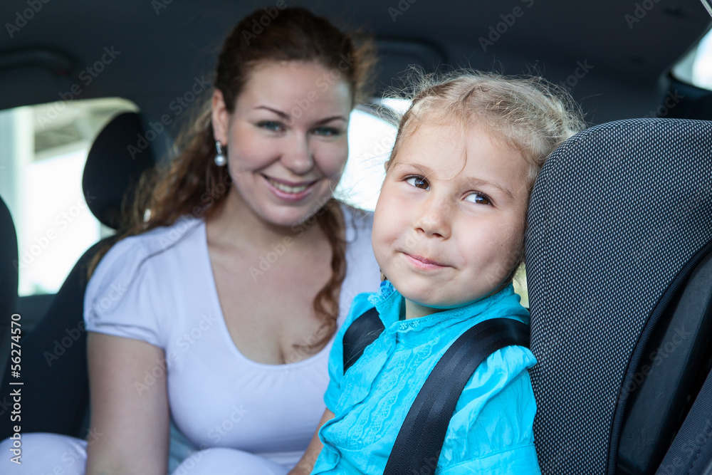 Mom with daughter sitting in car safety seat