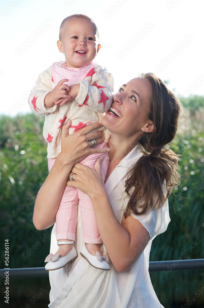 Young mother smiling outdoors with adorable baby Young mother smiling outdoors with adorable baby