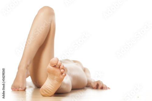 Foto naked woman lying on the floor with a focus on feet
