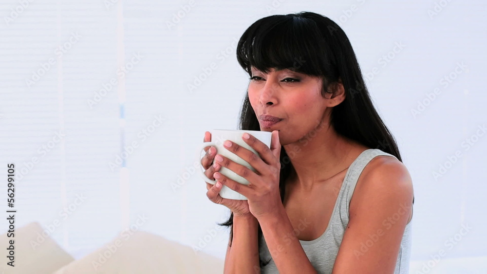 Attractive woman enjoying her morning coffee on her bed Attractive woman enjoying her morning coffee on her bed