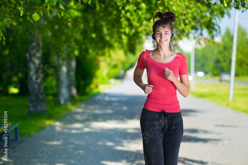 Runner - woman running outdoors in green park