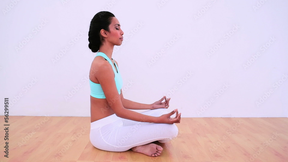 Peaceful woman meditating in lotus position