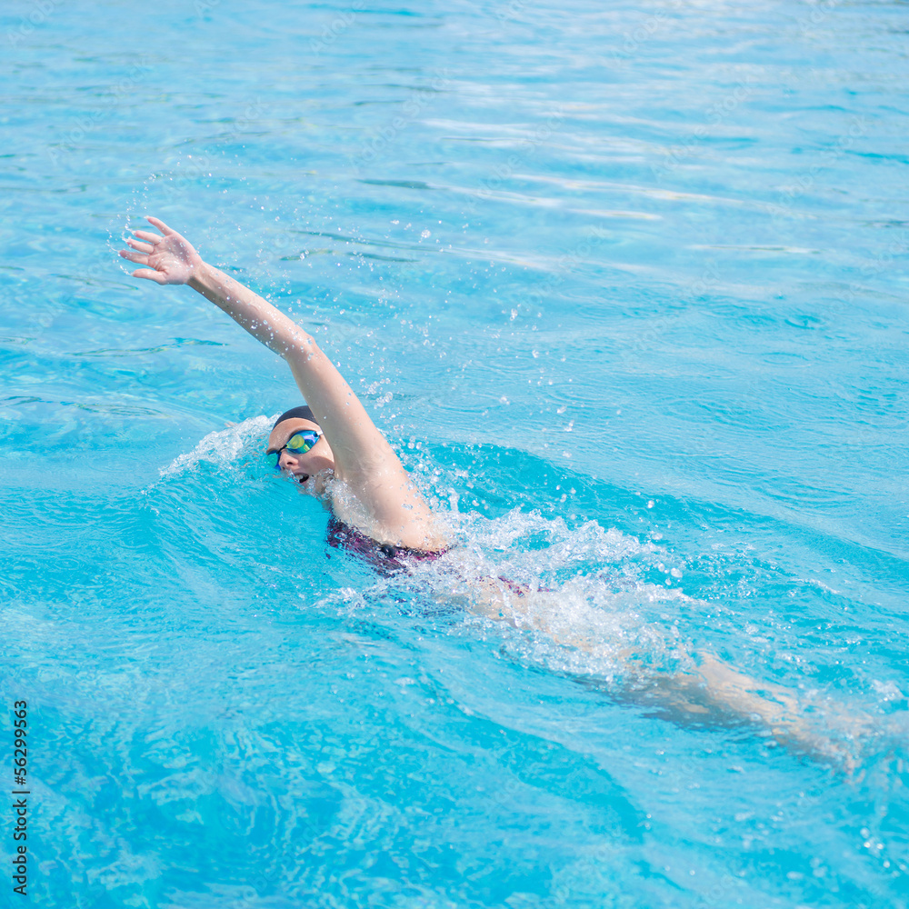 Woman in goggles swimming front crawl style
