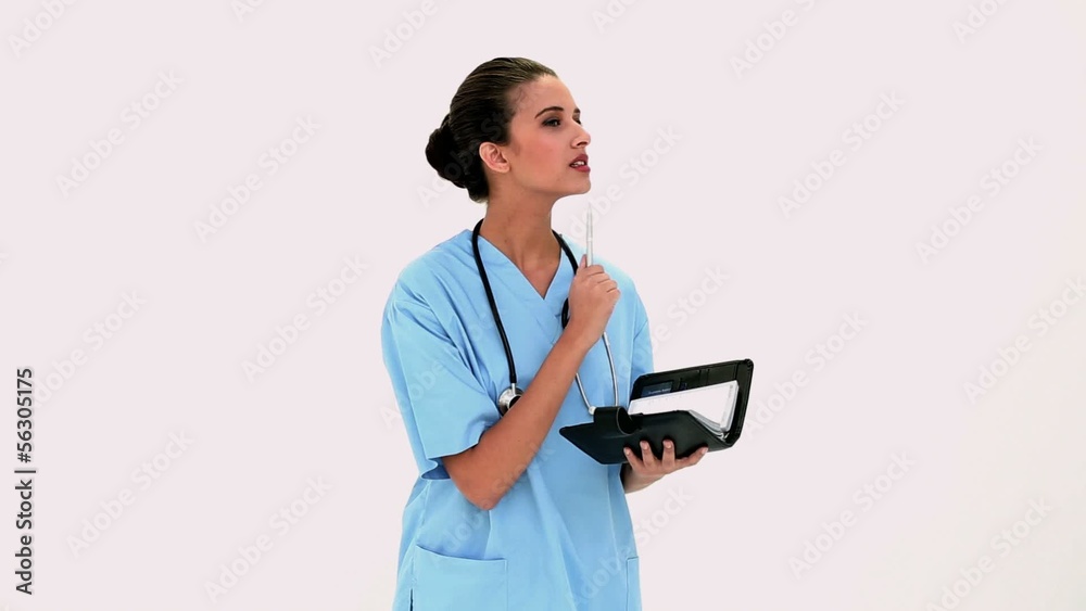 Pensive beautiful nurse checking a schedule Pensive beautiful nurse checking a schedule