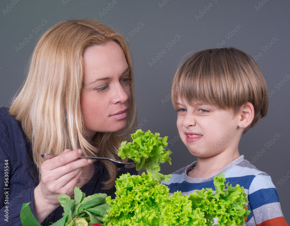 Little boy refusing to eat green salad Little boy refusing to eat green salad