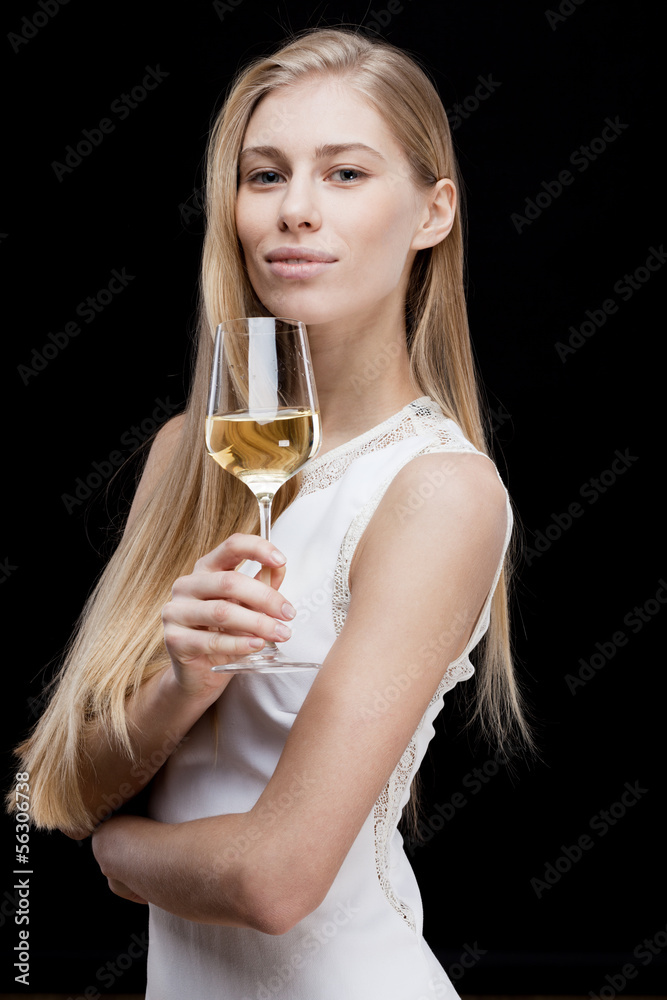 young blond woman holding glass of white wine young blond woman holding glass of white wine