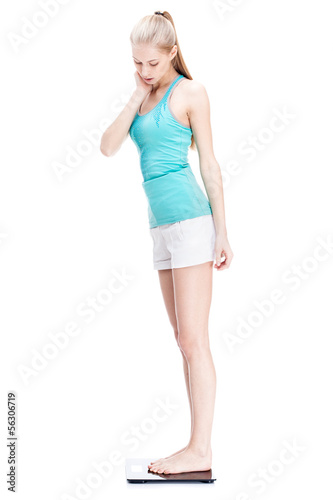 young blond woman standing on scales
