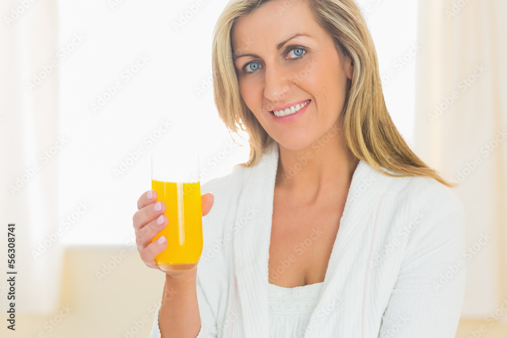 Content woman looking at camera enjoying a glass of orange juice Content woman looking at camera enjoying a glass of orange juice