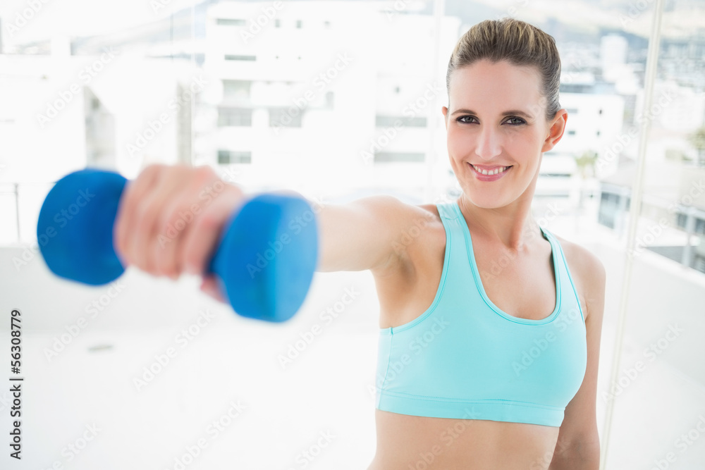Portait of smiling woman exercising with dumbbell Portait of smiling woman exercising with dumbbell