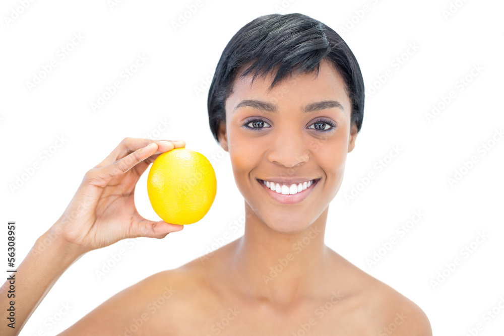 Natural black haired woman holding an orange Natural black haired woman holding an orange