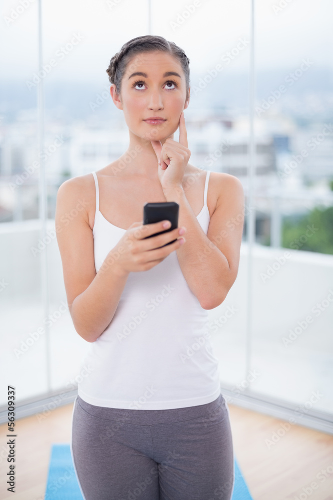 Thoughtful sporty brunette text messaging Thoughtful sporty brunette text messaging