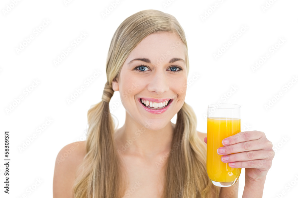 Delighted young blonde woman holding a glass of orange juice Delighted young blonde woman holding a glass of orange juice