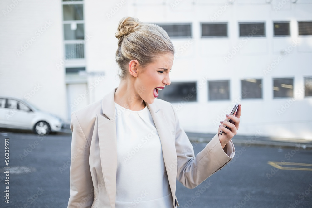 Fototapeta premium Furious stylish businesswoman shouting at her phone