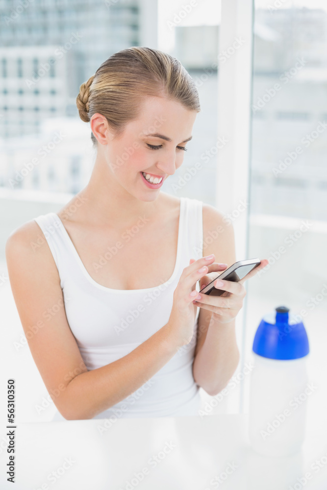 Happy blond woman sending a text message Happy blond woman sending a text message