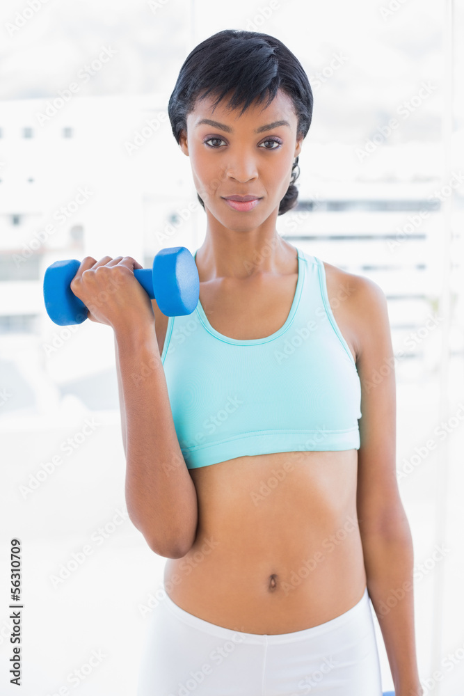 Stern black haired woman holding a dumbbell Stern black haired woman holding a dumbbell