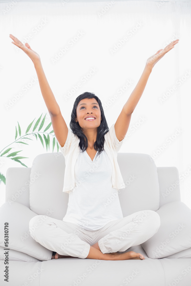 Cheerful black haired woman in white clothes raising her arms Cheerful black haired woman in white clothes raising her arms